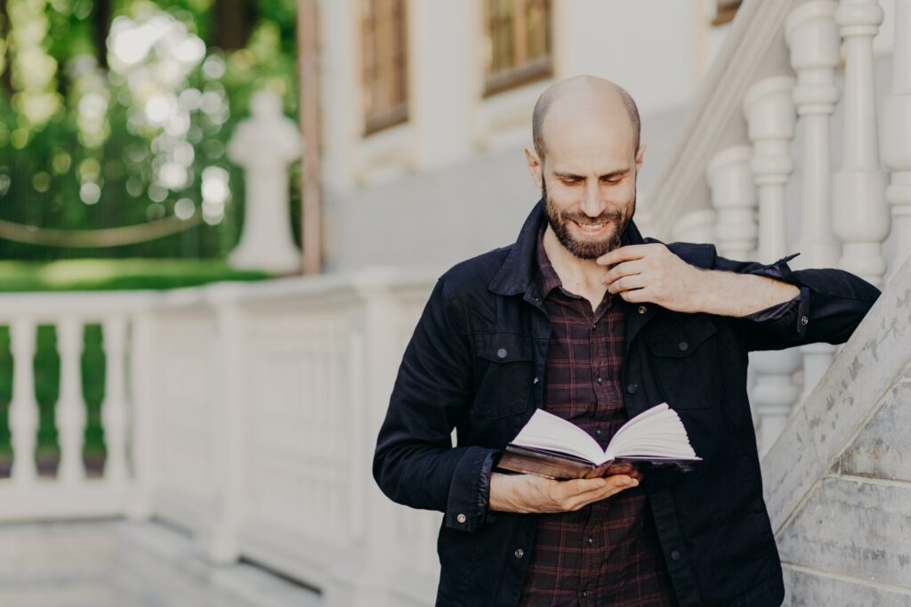 Clever middle aged student learns and cramps information before final exam, focused in book